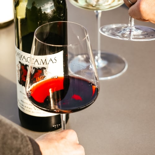 Close up of wine glass on table next to wine bottle