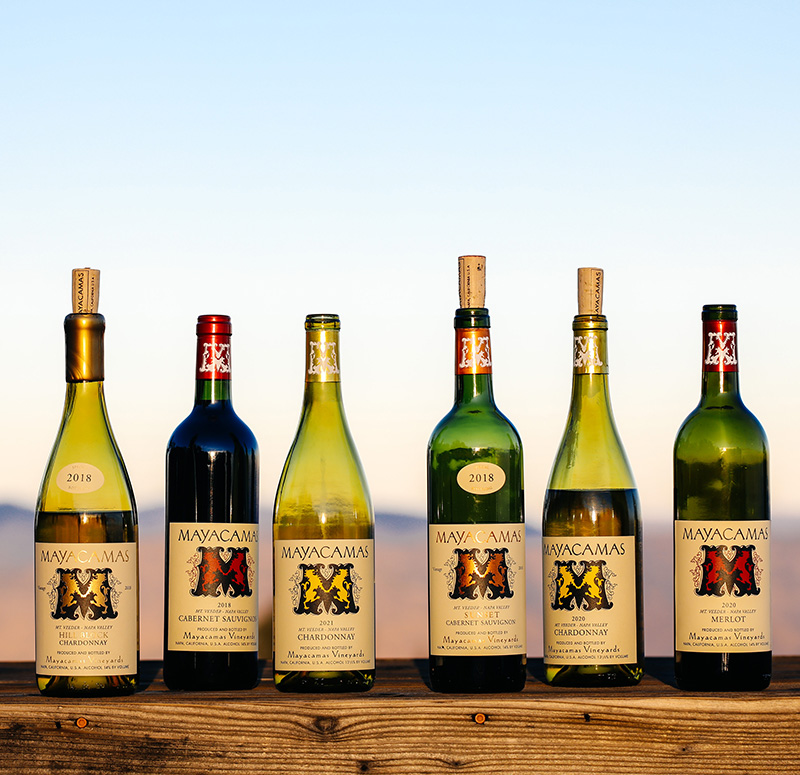 Bottles sitting on a table with a view from Mayacamas estate in background