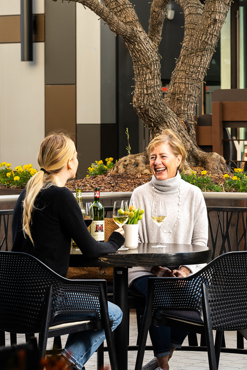 Two women sitting outside and drinking wine at Mayacamas downtown