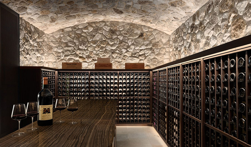 Bottle of Mayacamas wine and glasses on table in wine cellar