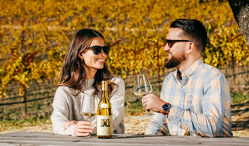 Couple drinking Mayacamas chardonnay at picnic table in fall