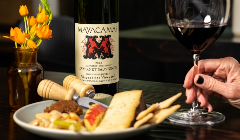 Woman drinking Mayacamas cabernet sauvignon with a cheese plate at Downtown tasting room